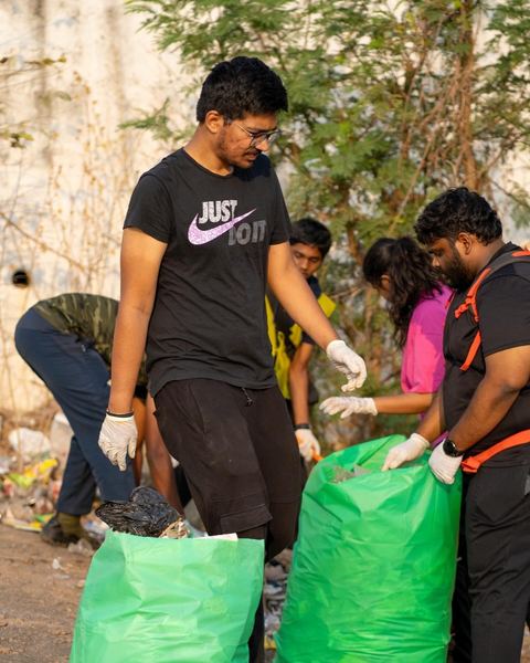 Volunteers filling green sacks on the hillside
